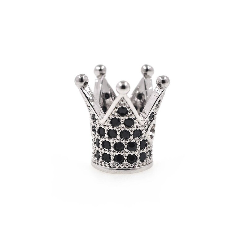 May include: A silver crown with black cubic zirconia stones. The crown is a popular design for jewelry and accessories.