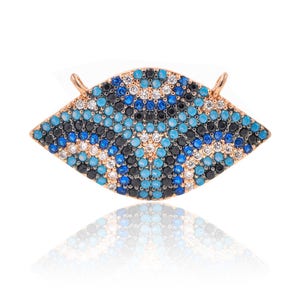 May include: A gold-toned pendant in the shape of an eye with blue, black, and white stones. The eye is a popular symbol of protection and good luck.