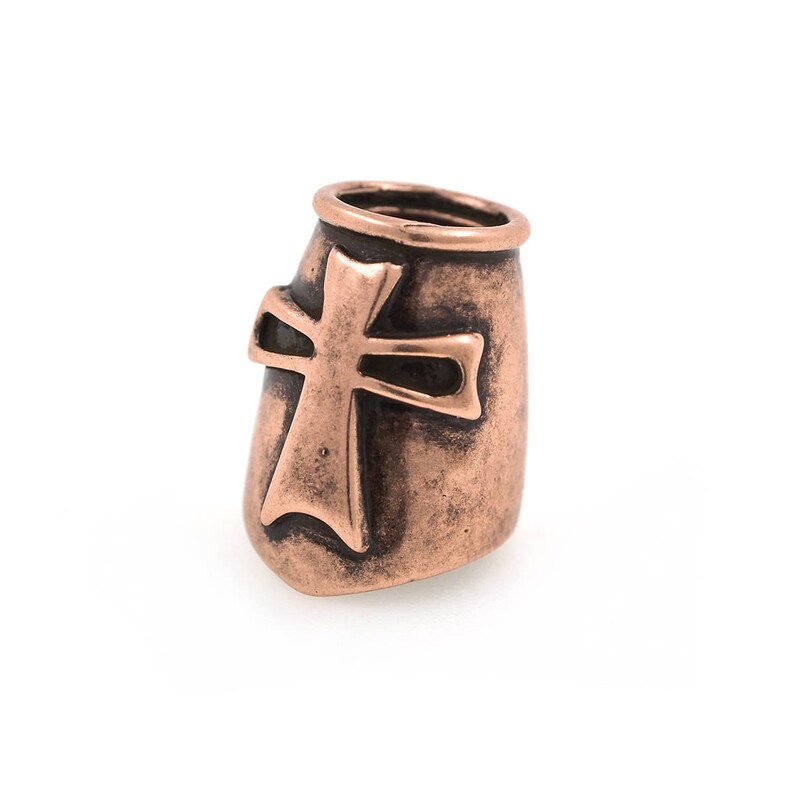 May include: A copper-colored metal bead with a cross design. The bead has a cylindrical shape with a flared top and a cross cutout on the front. The metal has a slightly textured surface and a warm, reddish-brown hue. Ideal for jewelry making.