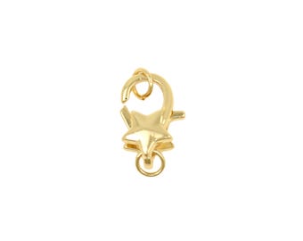 May include: A gold-colored lobster clasp with a star-shaped design. The clasp features a spring-loaded mechanism and a small ring for attaching to jewelry or other items. The star is centered on the clasp, adding a decorative element.