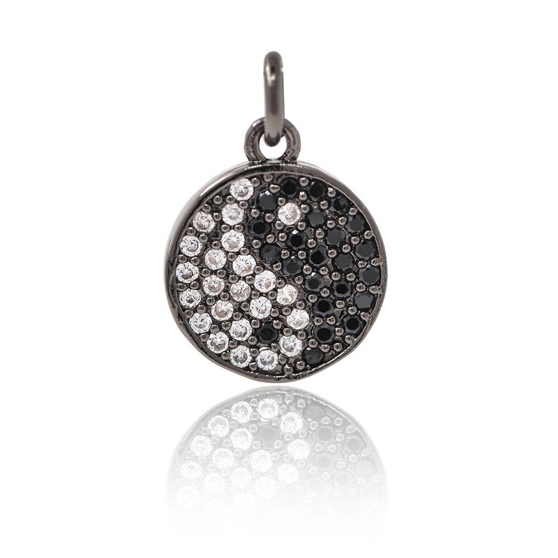 May include: A black pendant with a yin yang symbol design, featuring black and white cubic zirconia stones.