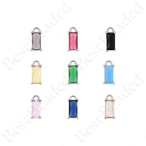Peut inclure: Assortiment de dix pendentifs rectangulaires avec des cadres en métal argenté et des pierres en verre colorées. Les pierres sont de couleur rose, rouge, noir, jaune, vert, bleu, bleu clair, bleu foncé et transparent.