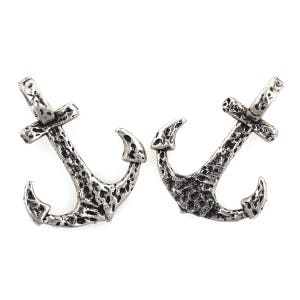 May include: Two silver-toned anchor charms with a textured surface. The anchors have a loop at the top for attaching to jewellery or other crafts.