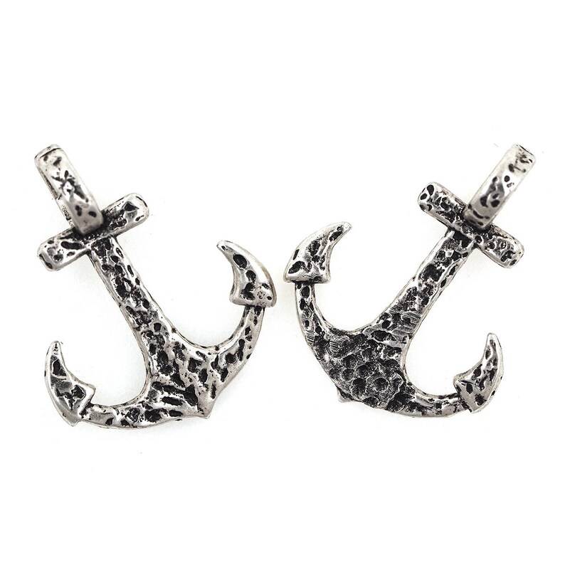 May include: Two silver-toned anchor charms with a textured surface. The anchors have a loop at the top for attaching to jewellery or other crafts.