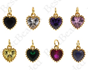 May include: A collection of heart-shaped pendants in various colors, including black, clear, purple, pink, yellow, green, red, and blue. Each pendant features a gold-colored frame with a beaded edge and a small loop for hanging.
