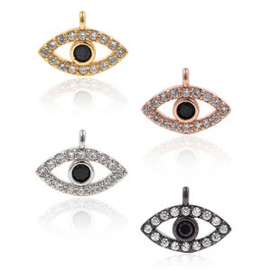 May include: Four gold, silver, rose gold, and black evil eye charms with clear crystal accents. Each charm features a black eye in the centre.