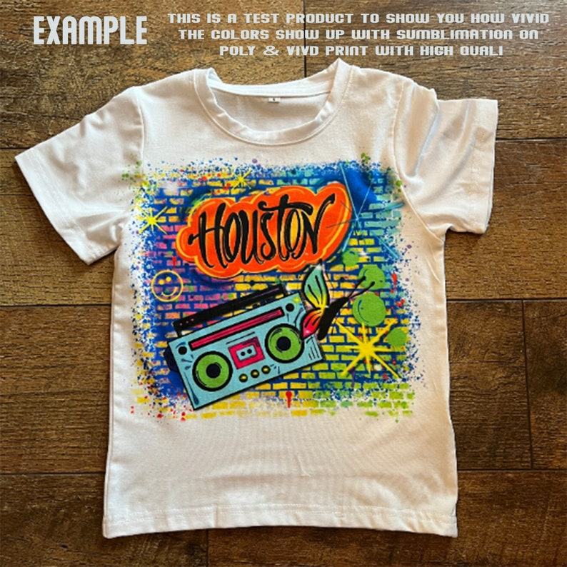 May include: White t-shirt featuring a colourful graphic print of a boombox, a butterfly, and the word "Houston" in graffiti style.