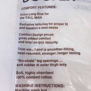 May include: White packaging with brown text describing the features of Jockey underwear. The text includes "Extra Long Rise for the TALL MAN", "Comfort Design pouch", "Trim waistband", "No-chafe" leg openings", "Soft, highly absorbent", "100% combed cotton", "Machine wash hot", and "Tumble dry".