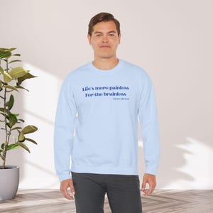 May include: A light blue sweatshirt with the text "Life's more painless for the brainless" in blue lettering. The text is attributed to "Flyers, Michael".