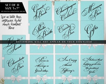 May include: A set of 11 digital signs measuring 5x7 inches, featuring a light blue background with a white ribbon and bow at the bottom. Each sign displays black cursive text including Guest Book, Champagne Cocktails, Mimosa Bar, Photo Booth, Candy Bar, Gifts, Love is Sweet, Chocolate Bar, Paris is Always a Good Idea, I'm Crazy About Tiffany's, and I believe that happy girls are the prettiest girls.