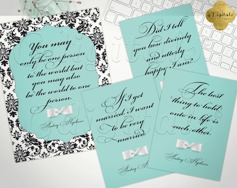 May include: Four rectangular prints featuring black cursive text on light blue backgrounds, with one print set against a black and white damask pattern. Each print includes a small white bow graphic and quotes attributed to Audrey Hepburn.