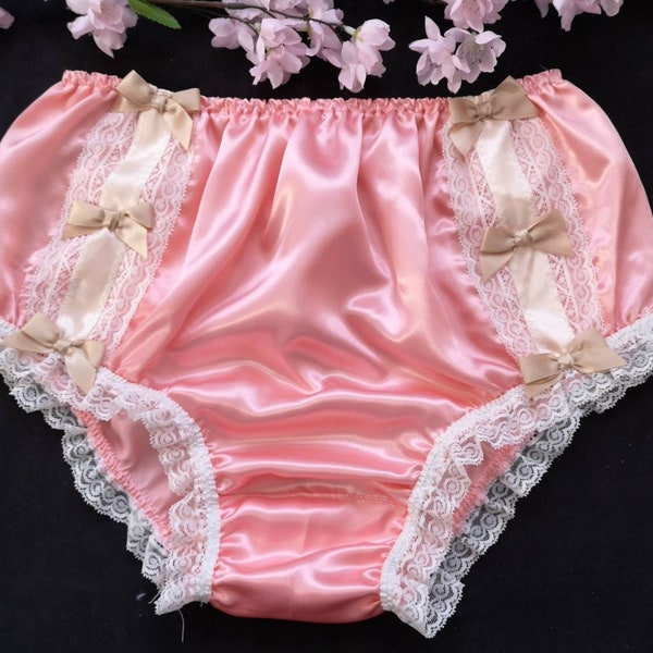 May include: Pink satin panties with white lace trim and beige bows.
