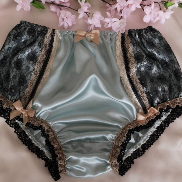May include: Light blue satin panties with black and beige lace trim and bows. 