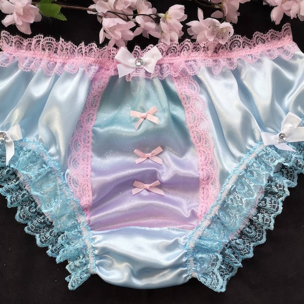 May include: Light blue satin underwear with a pink lace trim and blue lace trim. The underwear has a satin bow with a rhinestone in the center on each side.
