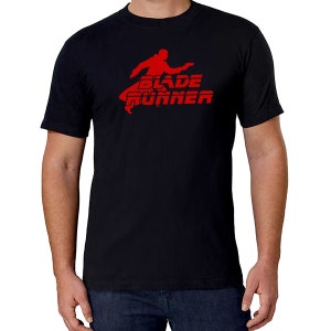Puede incluir: Camiseta negra con una silueta roja de una persona corriendo y el texto "Blade Runner" en rojo.
