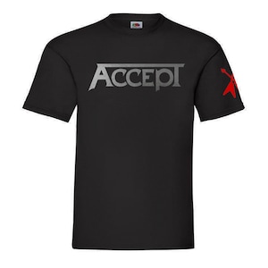 Può includere: T-shirt nero con un logo "ACCEPT" argentato e un design di plettro per chitarra rosso sulla manica.
