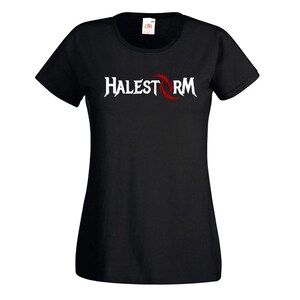 May include: Black t-shirt featuring the band name "HALESTORM" in white, with a red stylized design. The shirt has short sleeves and a crew neck. The band's logo is centered on the front.