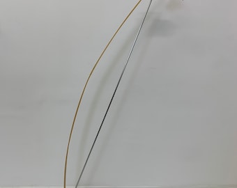 Pode incluir: Um candeeiro de chão de cromo e madeira com uma base branca e um braço curvo. O candeeiro tem um cabo branco e um abajur branco.