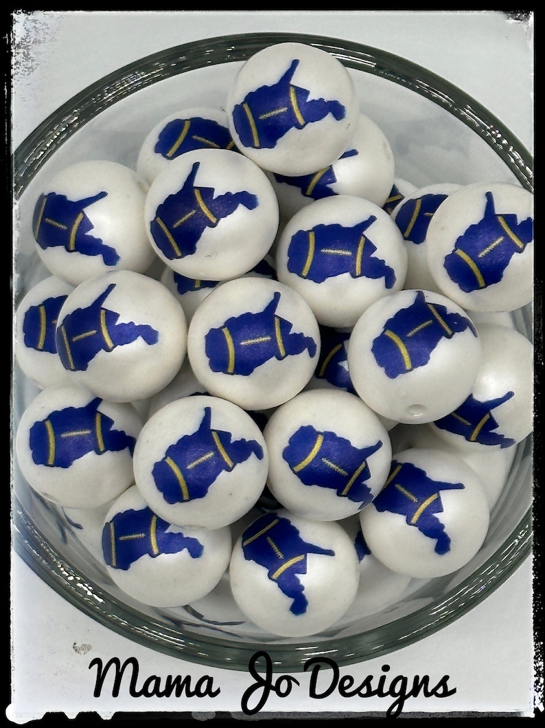 May include: A bowl of white wooden beads with a blue and gold outline of the state of West Virginia. The beads are perfect for crafting and jewelry making.