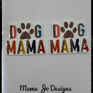 以下が含まれることがあります： 虹色のフォントで「Dog Mama」と書かれた2つのカラフルなステッカー。ステッカーには、ヒョウ柄のデザインの足跡が描かれています。