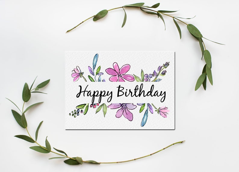 Może przedstawiać: Biała kartka z akwarelowym obramowaniem kwiatowym i tekstem "Happy Birthday" czarnym pismem.