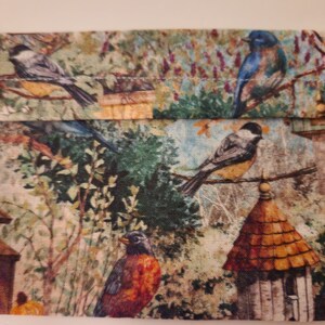 May include: A fabric pouch with a colorful bird print. The pouch features a variety of birds, including bluebirds, chickadees, and robins, perched on branches and in birdhouses. The fabric is a light beige with a subtle texture.