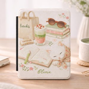 May include: A white tablet case with a whimsical illustration featuring a sleeping cat, books, sunglasses, and a drink. The case has the name "Olivia" and the word "books" on a tote bag. The design includes floral accents.
