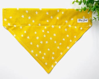 May include: Yellow dog bandana with a white star pattern. The bandana has a white label that says "Flora Soul Boutique".