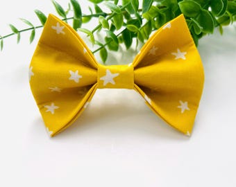 May include: A yellow bow tie with white stars printed on it.