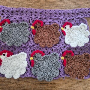 May include: A purple crocheted panel featuring six appliqued chickens in white, brown, and gray. Each chicken has a red comb and wattle with a yellow beak. The background is a purple square-patterned crochet mesh with a top border strap.