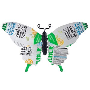 May include: A decorative butterfly made from a repurposed beverage can. The wings are white with green and yellow accents, and text that reads "BOOSTS ENERGIZES & RESTORES BALANCE". The body is black with wire antennae.
