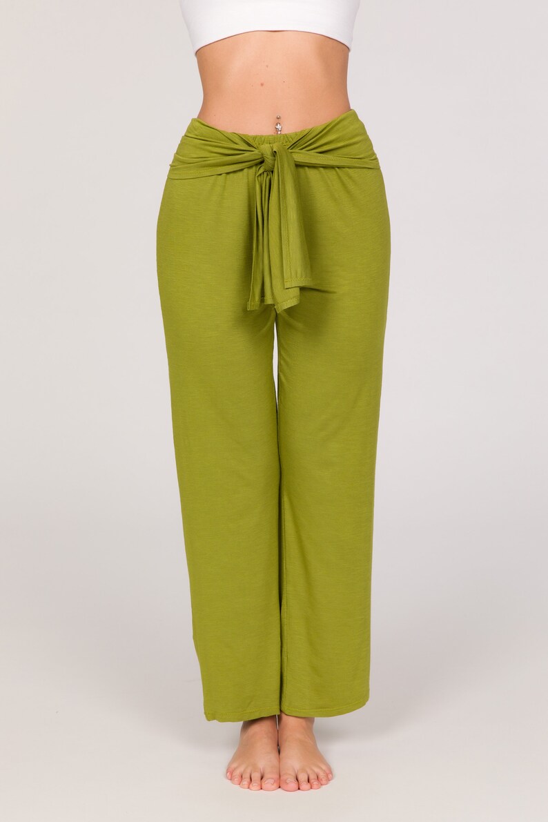 May include: Lime green wide-leg trousers with a tie-waist feature. The trousers are made from a soft, flowing material. The image shows the trousers against a plain white backdrop.