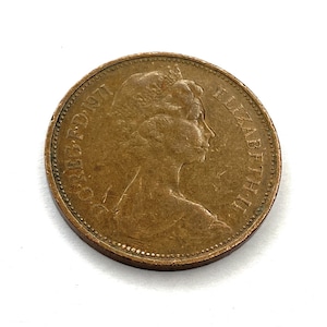 May include: A copper-coloured British one penny coin with the inscription "REG FD 1971" and "ELIZABETH II" around the edge.