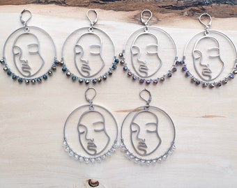 Large silver hoops with abstract female face wire wrapped with glass crystal beads