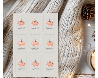 Puede incluir: Una hoja de nueve pegatinas rectangulares. Cada pegatina presenta un cerdo rosa con una vela en la espalda y el texto "hyggelig jul" en escritura a mano. El fondo es gris claro con pequeños puntos blancos.