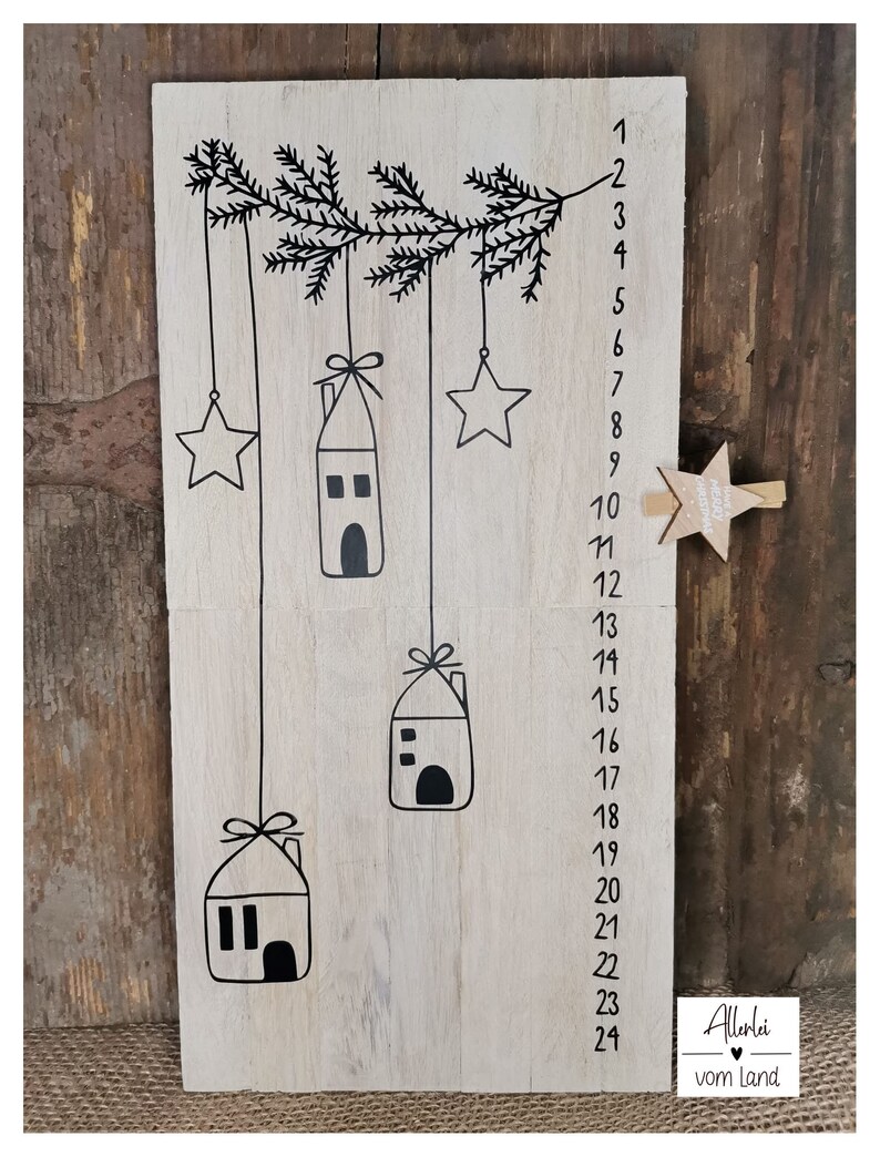 May include: A wooden advent calendar with 24 numbered windows, each with a small house and star hanging from a branch. The calendar is decorated with the text "Allerlei vom Land".