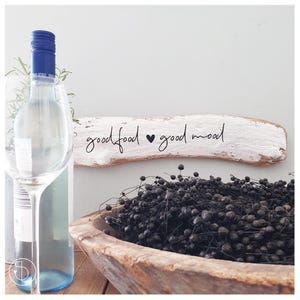Puede incluir: Un letrero de madera pintado de blanco con el texto "good food good mood" en escritura negra con un símbolo de corazón entre las palabras.