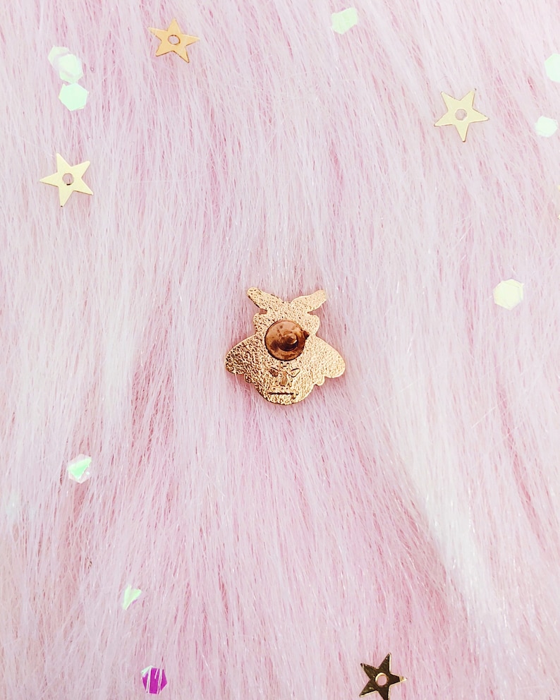 May include: Gold bee pin on a pink fuzzy background with gold glitter stars.