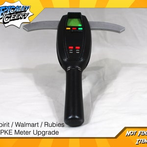 May include: A black and silver Ghostbusters PKE Meter prop with a digital display and red and green lights. The prop is labeled "Spirit / Walmart / Rubies PKE Meter Upgrade" and "NOT FINISHED ITEM".