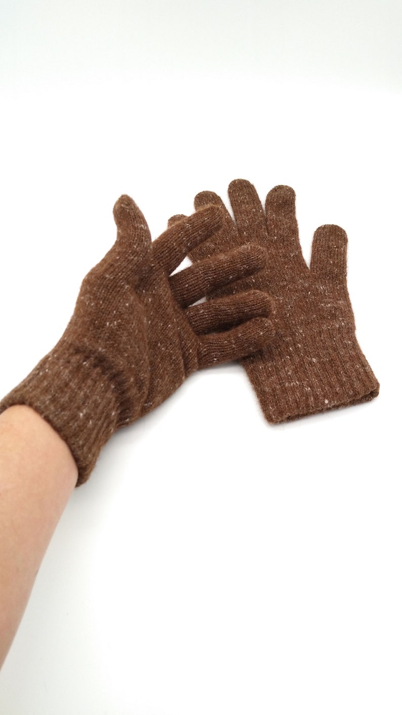 May include: A pair of brown knit gloves with a speckled texture. The gloves are shown on a white background.