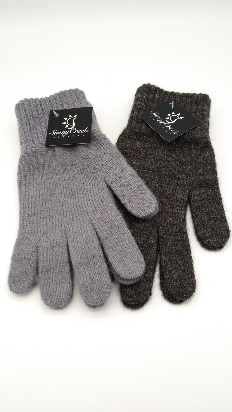 May include: Two pairs of alpaca knit gloves, one gray and one brown. The gloves are made by Sunny Creek Alpacas.