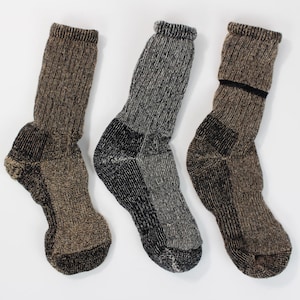 May include: Three pairs of brown and black wool socks. The socks have a textured knit pattern.
