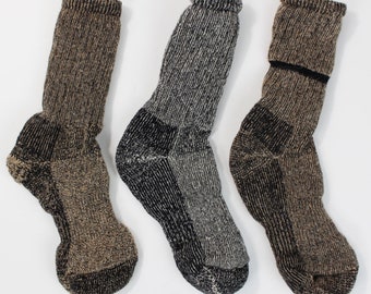 May include: Three pairs of brown and black wool socks. The socks have a textured knit pattern.