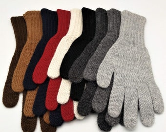 Puede incluir: Un conjunto de diez pares de guantes de punto en varios colores, incluyendo marrón, rojo, blanco, negro, gris y azul. Los guantes están doblados y apilados uno encima del otro.