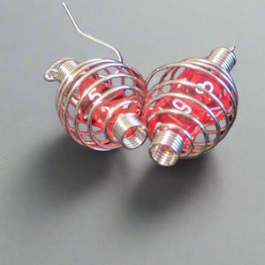 Gamer earrings. Stainless steel spiral cage encloses two rpg dice.
