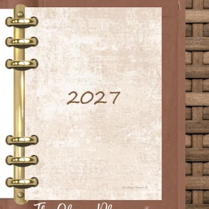 May include: A brown leather-look binder with a gold-toned six-ring metal mechanism. The inner page features a textured cream background with the year 2027 printed in brown. The text The Clever Planner is visible at the bottom.