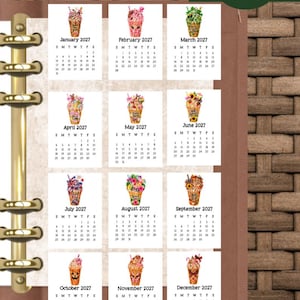 May include: A 2027 planner calendar page featuring twelve monthly sections, each topped with a unique, colorful illustration of a decorated beverage cup. The text "The Clever Planner" appears in the top right corner above the grid of months.