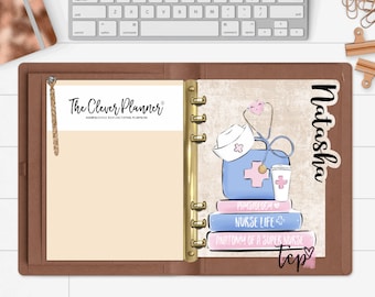 May include: A brown leather planner with a gold ring binder. The left page has a beige background with the text "The Clever Planner" and a brown tassel. The right page has a sticker with a nurse's hat, stethoscope, first aid kit, coffee cup, and books with the text "Physiology", "Nurse Life", and "Anatomy of a Super Nurse". The sticker also has the name "Natasha" and a pink heart.