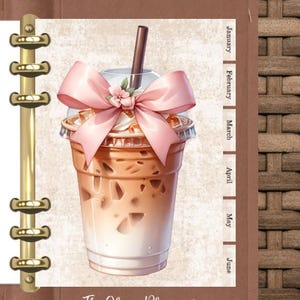 May include: A planner page featuring a detailed illustration of an iced coffee drink with a pink bow and flower. The page includes a gold binder spine, a calendar with months, and the text "The Clever Planner."