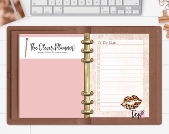 May include: A brown leather planner with gold rings. The left page is pink and has the text "The Clever Planner" in black. The right page has a to-do list with checkboxes and a leopard print lip design with the text "Tcp" in pink.